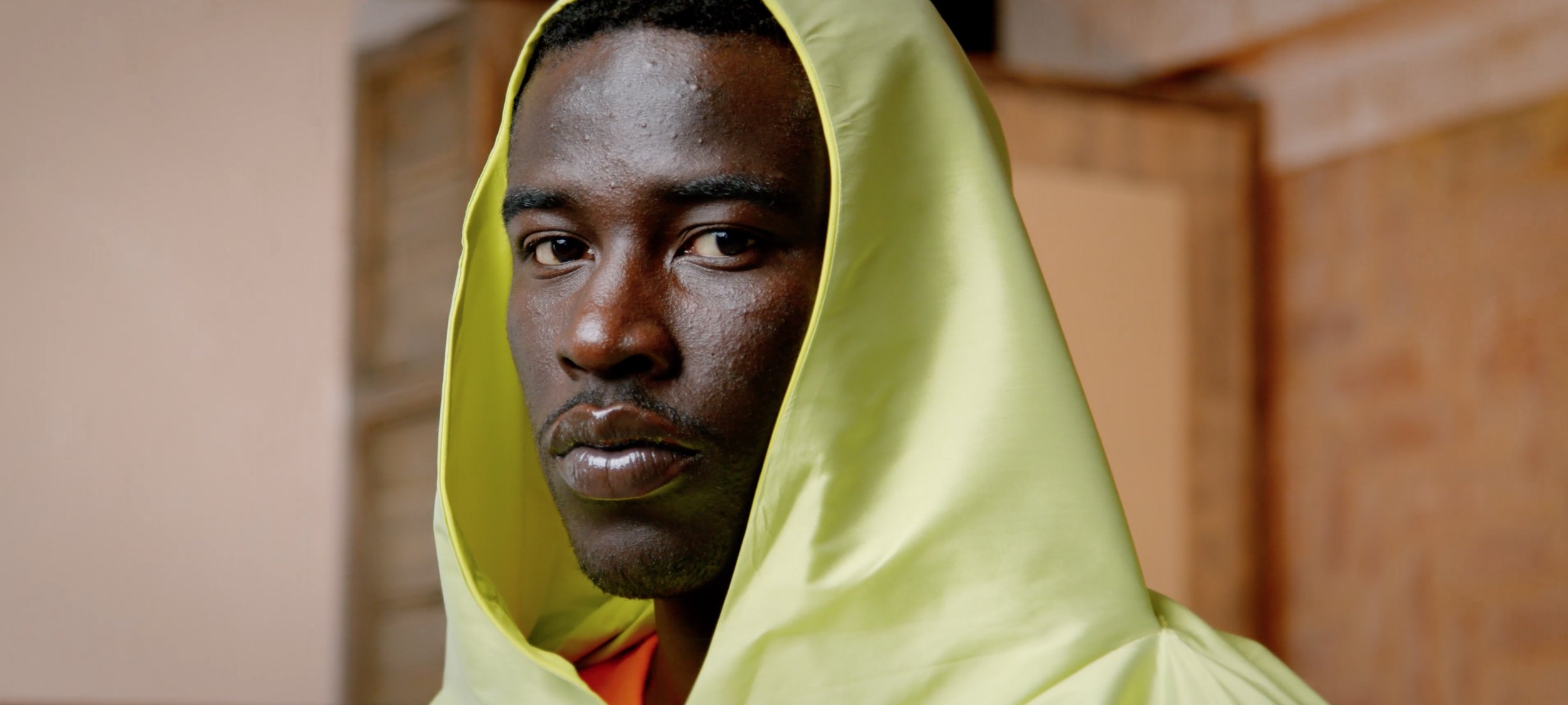 Young male model looks at camera in high fashion clothing.